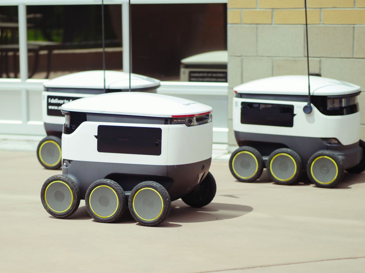 services-04 Advanced autonomous delivery robots in an outdoor urban setting, showcasing modern technology.